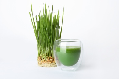 Photo of Glass of fresh wheat grass juice and sprouts on white background
