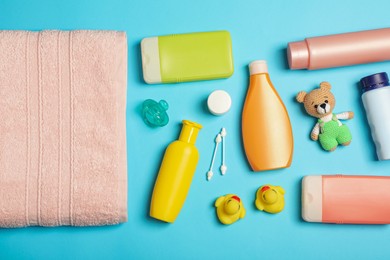 Flat lay composition with baby cosmetic products on light blue background