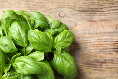 Photo of Fresh basil on wooden table, top view