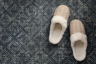 Pair of beautiful soft slippers on carpet, top view. Space for text