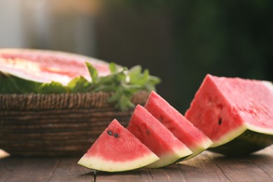 Photo of Slices of delicious ripe watermelon on wooden table outdoors