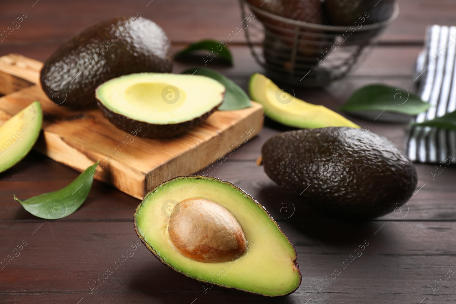 Photo of Fresh whole and cut avocados on wooden table