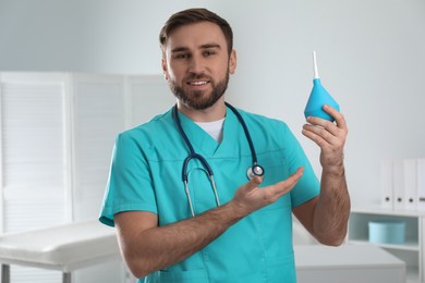 Photo of Doctor holding rubber enema in examination room