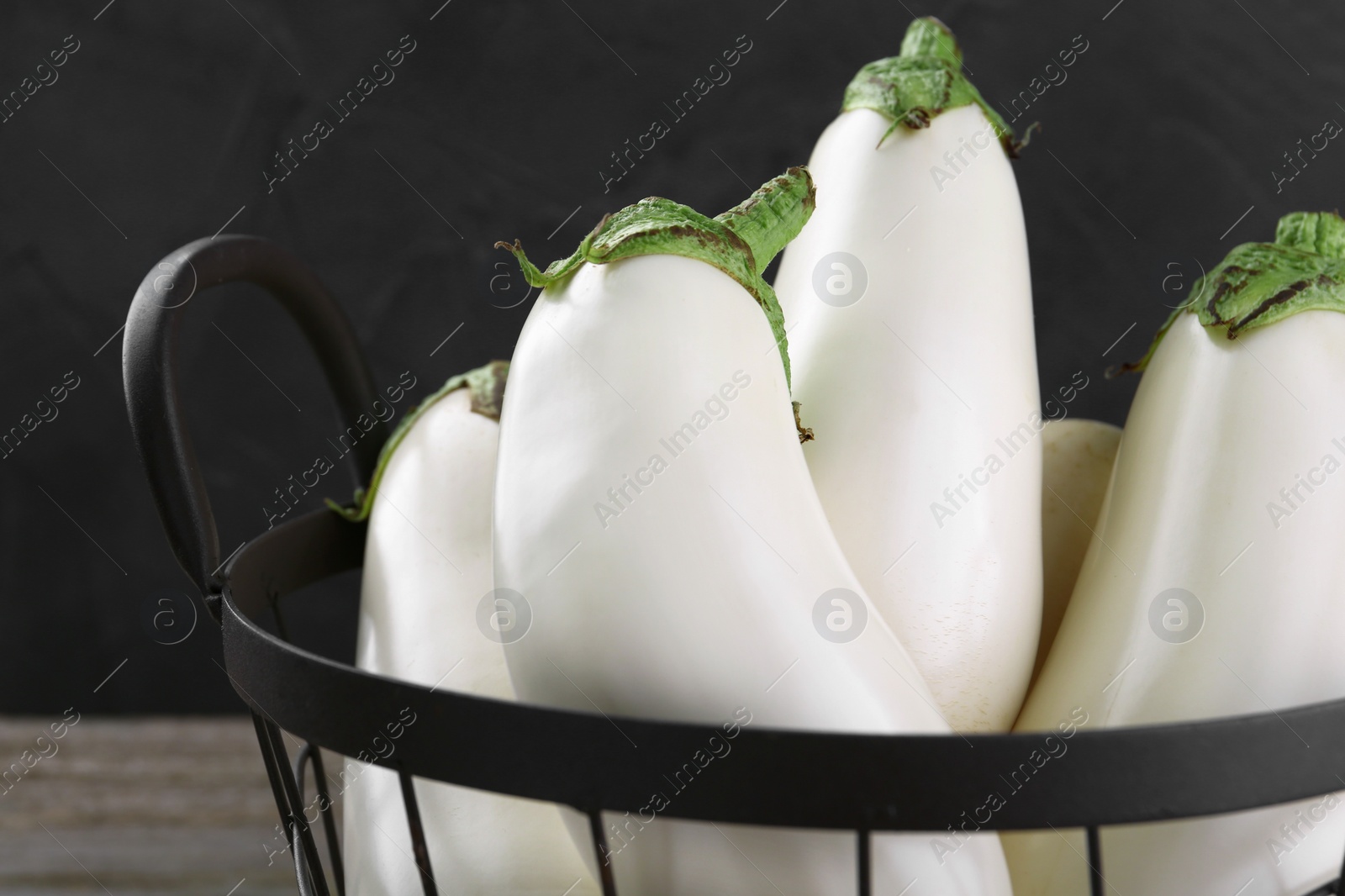 Photo of Many fresh white eggplants in metal basket, closeup