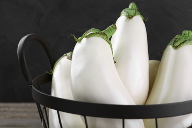 Many fresh white eggplants in metal basket, closeup