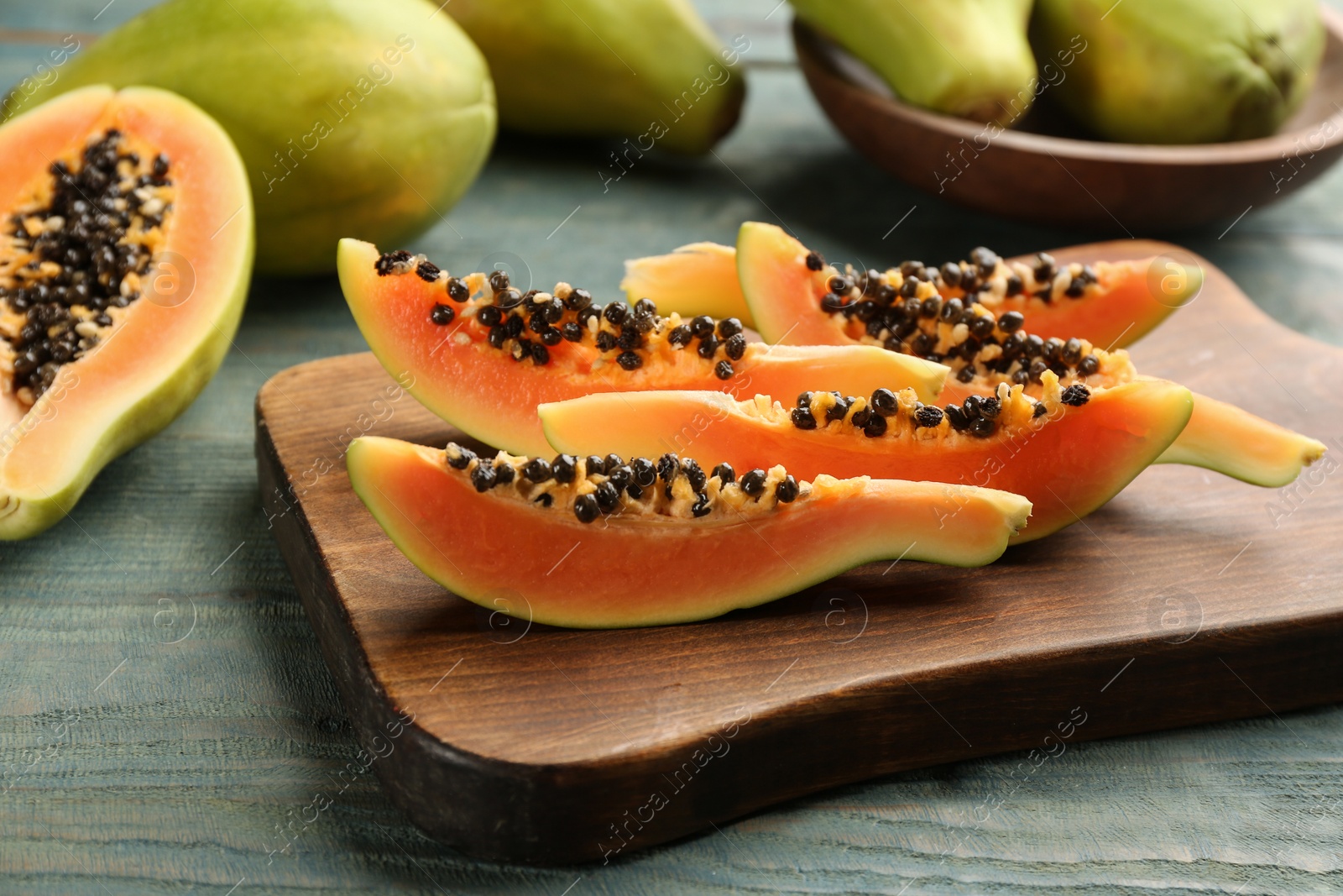 Photo of Fresh sliced papaya fruit on wooden table