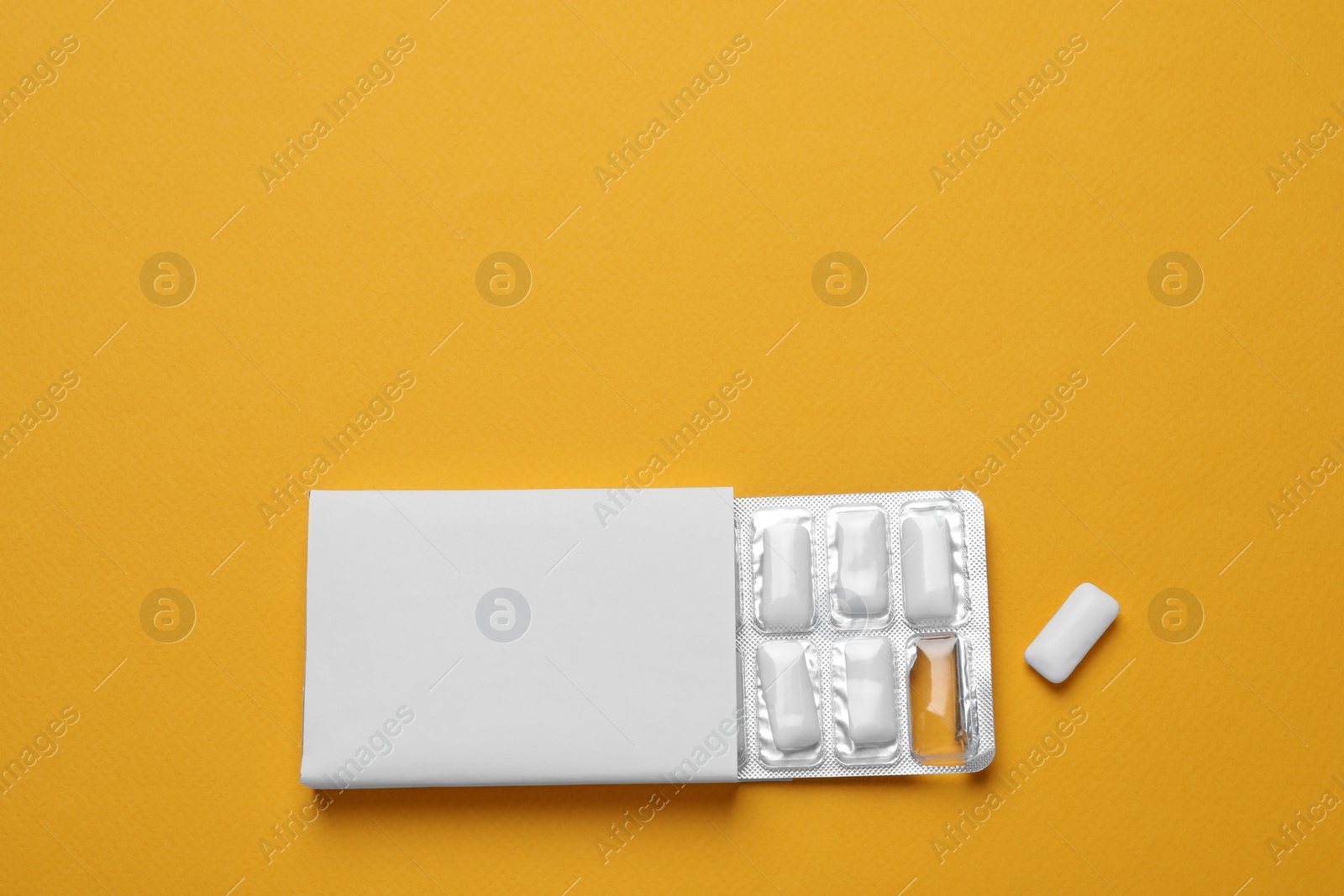 Photo of Pack with tasty chewing gums on orange background, flat lay. Space for text