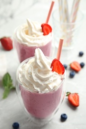 Photo of Tasty milk shake with strawberry on table, closeup