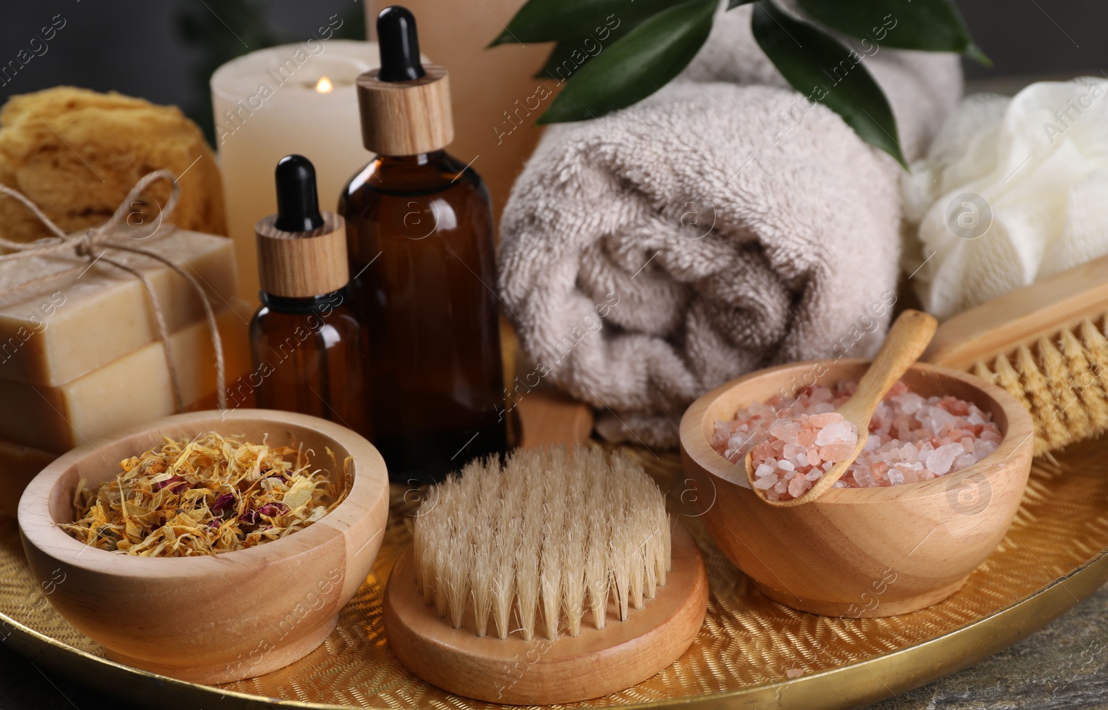 Photo of Spa composition. Brushes, bottles and sea salt on table, closeup