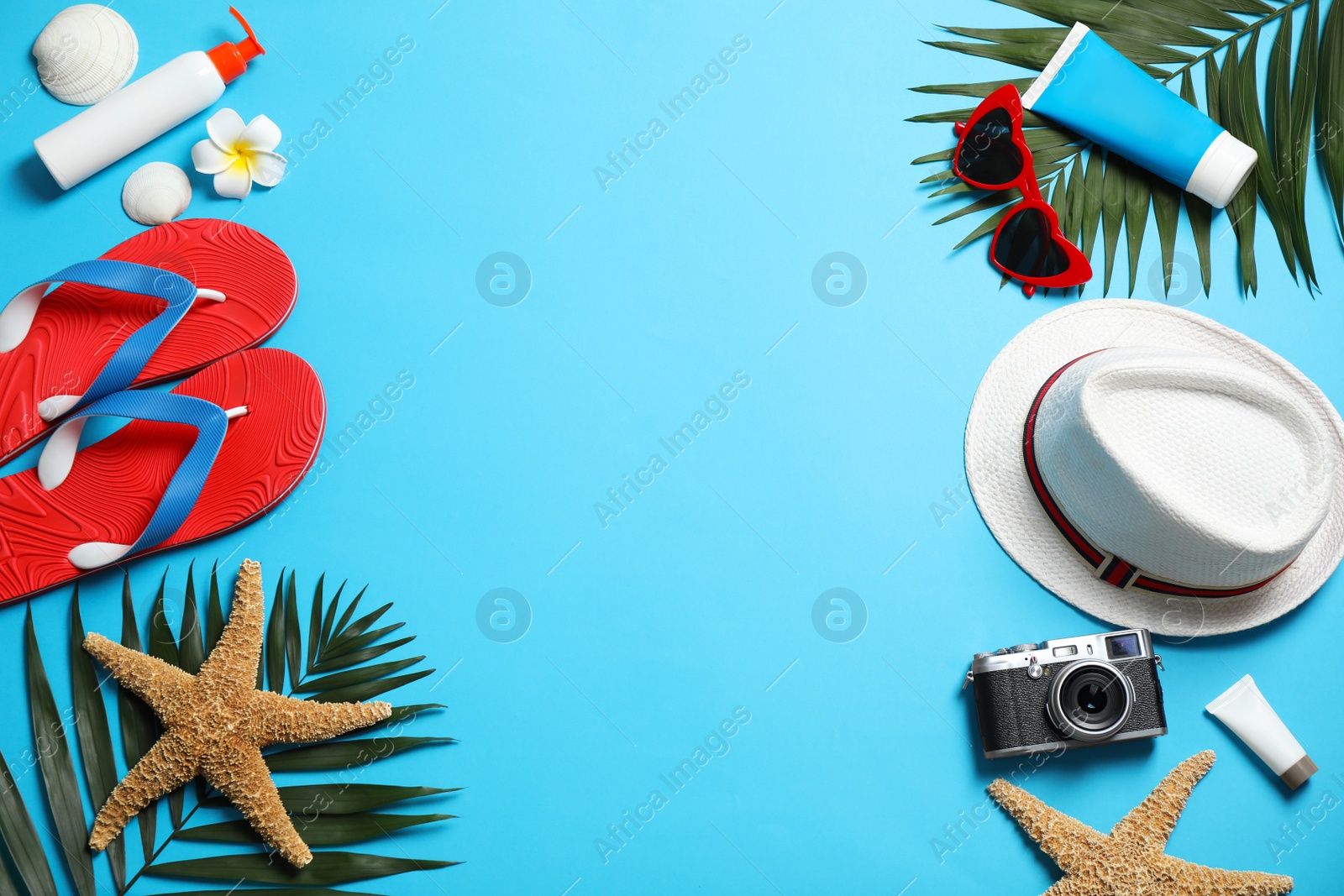 Photo of Flat lay composition with stylish beach accessories on light blue background, space for text