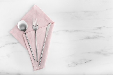 Photo of Stylish cutlery set and napkin on white marble table, flat lay. Space for text