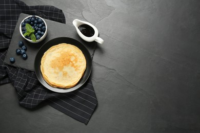 Photo of Delicious crepes with mint and blueberries on grey table, flat lay. Space for text