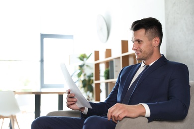 Photo of Male business trainer working with documents in office