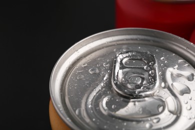 Photo of Energy drink in wet can on dark background, closeup