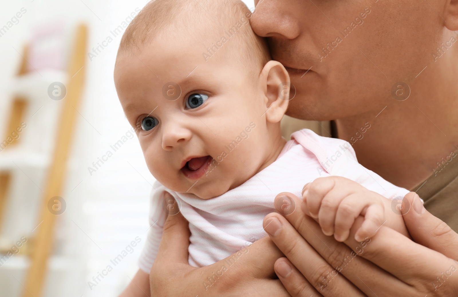 Photo of Happy father with his little baby at home, closeup