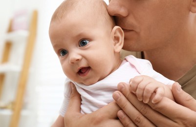 Photo of Happy father with his little baby at home, closeup