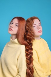 Photo of Portrait of beautiful young redhead sisters on light blue background
