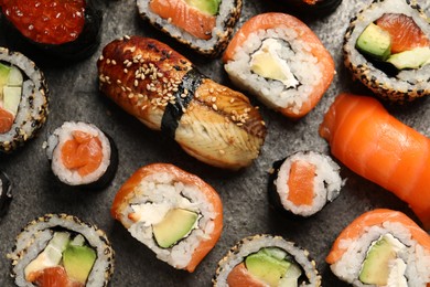 Different tasty sushi rolls on grey table, flat lay