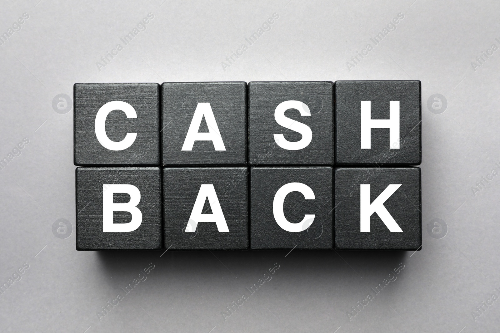 Photo of Word Cashback made with black wooden cubes on grey background, flat lay