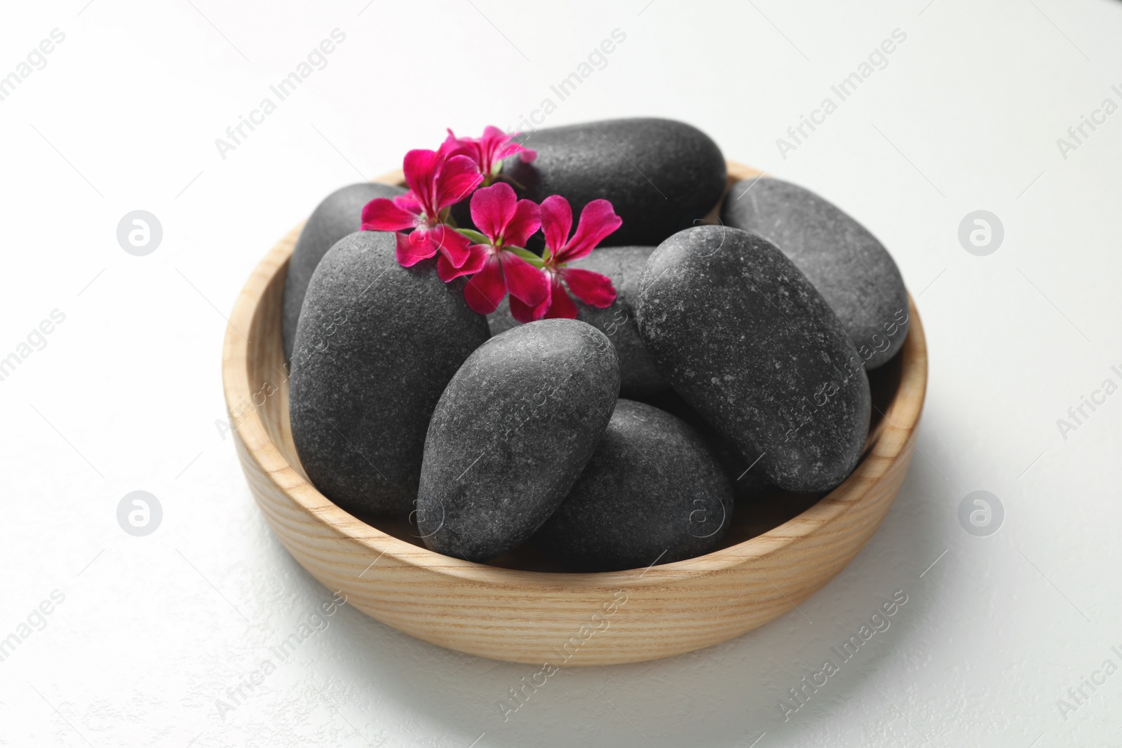 Photo of Spa stones and beautiful flowers on white table