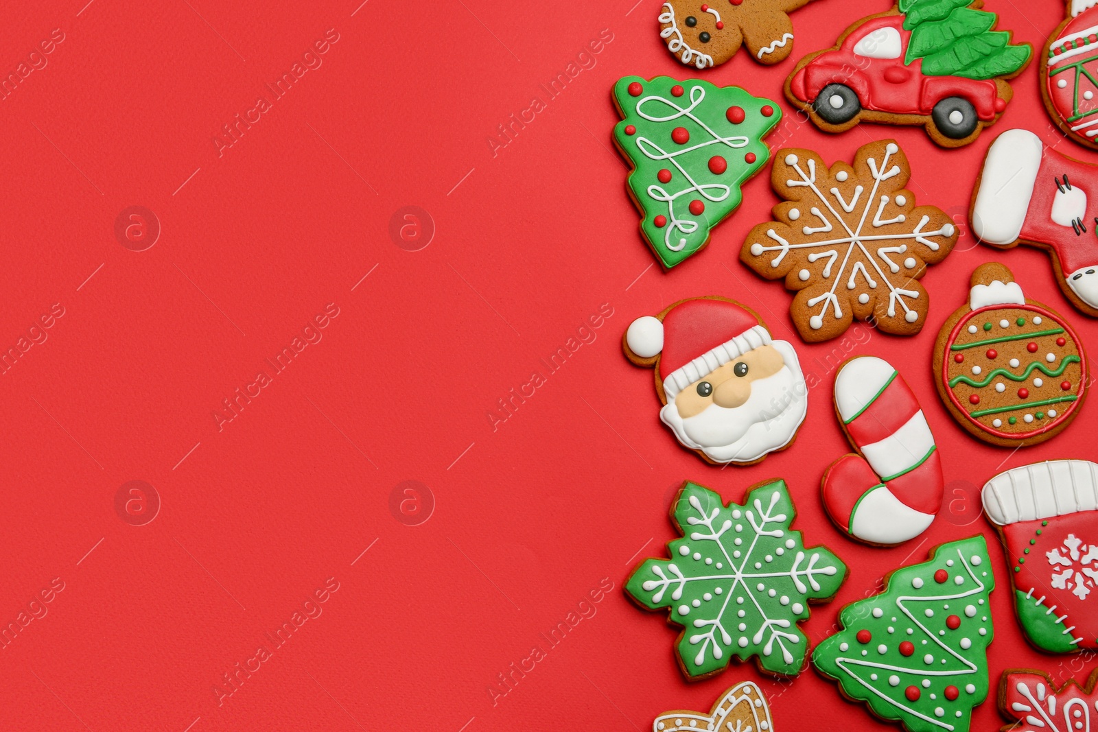 Photo of Different tasty Christmas cookies on red background, flat lay. Space for text