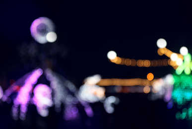 Photo of Blurred view of city street with festive lights at night. Bokeh effect