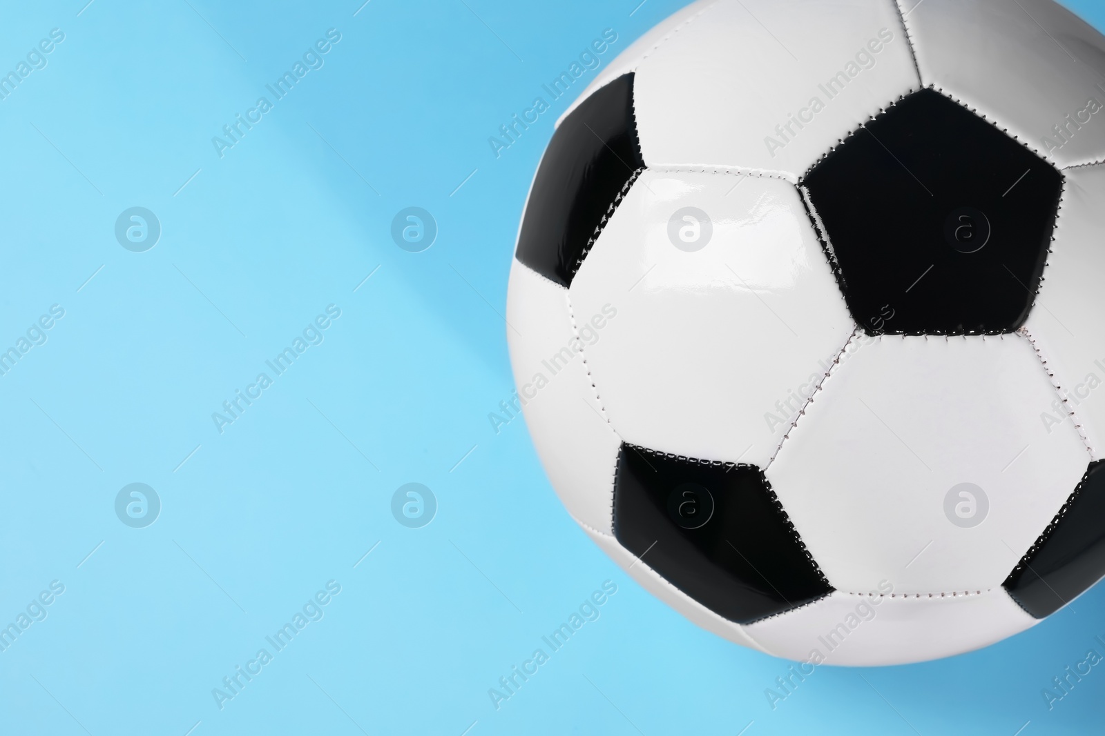 Photo of One soccer ball on light blue background, above view with space for text. Sports equipment