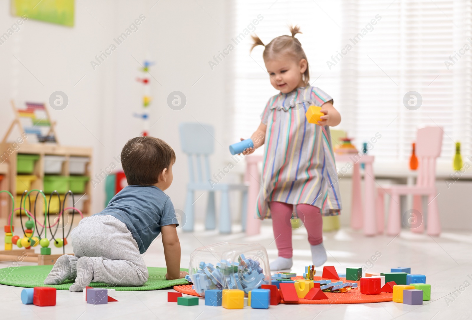 Photo of Cute little children playing together in room