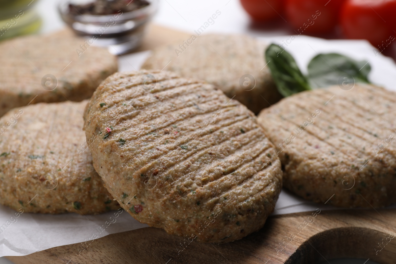 Photo of Raw vegan cutlets on wooden board, closeup