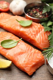 Fresh salmon and ingredients for marinade on wooden table, closeup