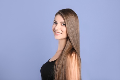 Photo of Portrait of young woman with long beautiful hair on grey background
