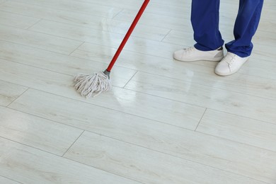 Man cleaning floor with mop indoors, closeup