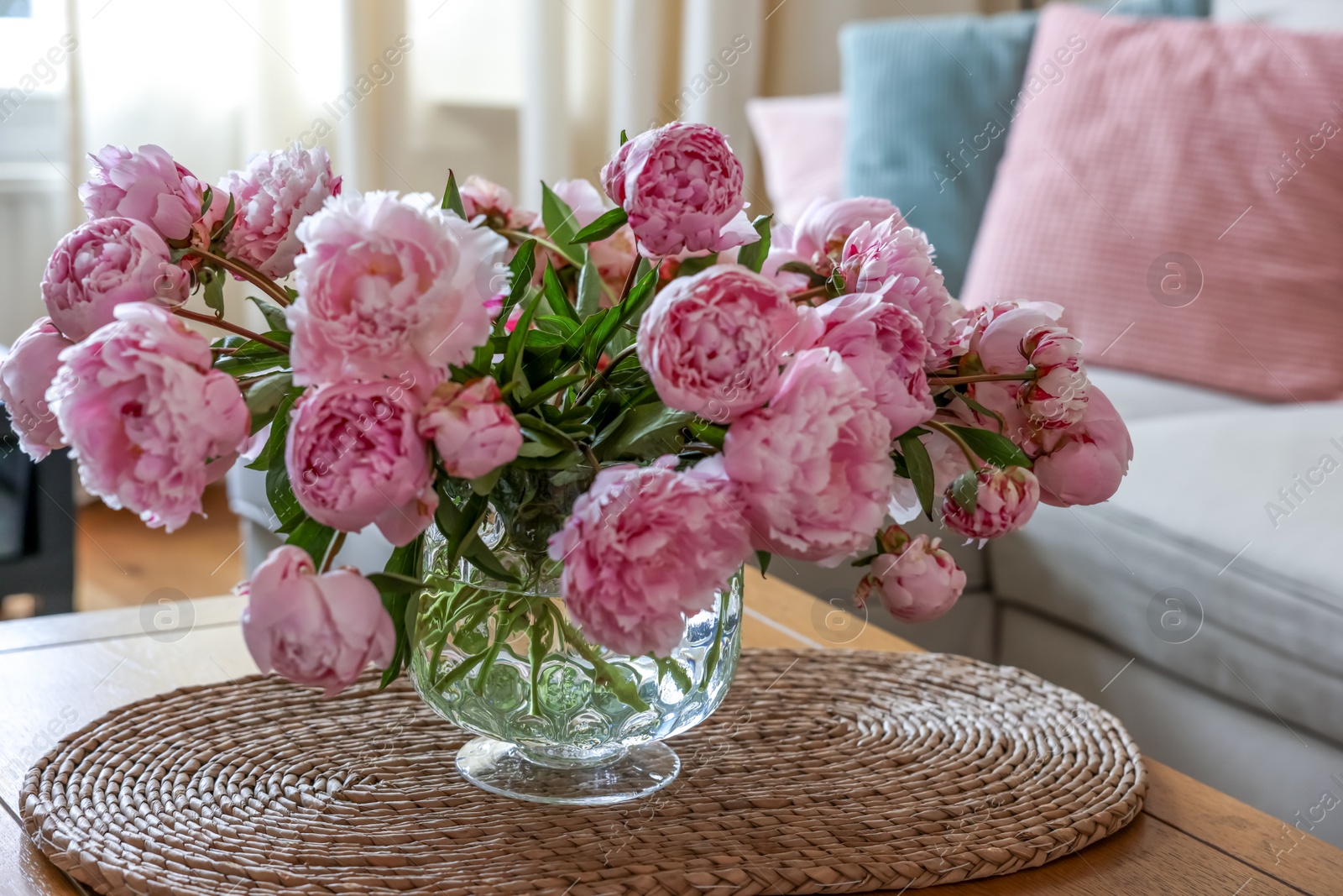 Photo of Beautiful pink peonies in vase on table at home. Interior design