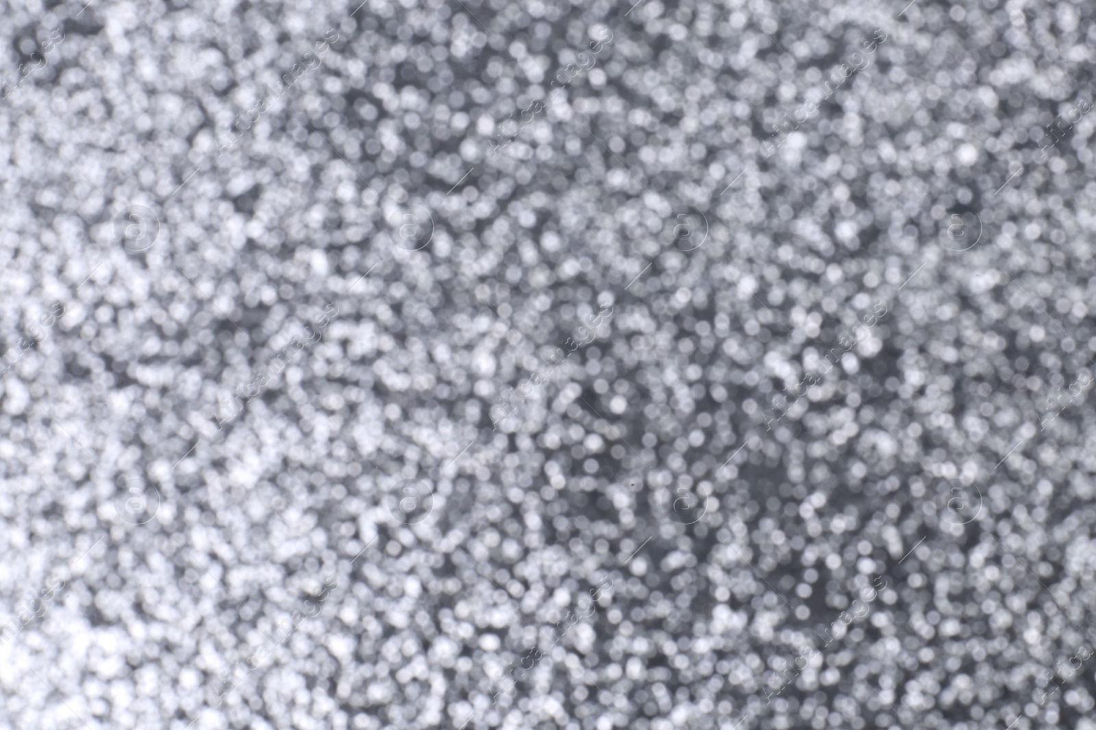 Photo of Blurred view of shiny silver glitter as background, closeup
