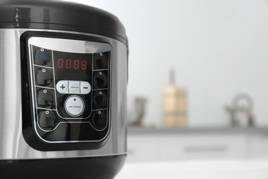 Modern multi cooker on table in kitchen, closeup. Space for text