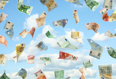Image of Falling Euro banknotes and blue sky on background. Money rain
