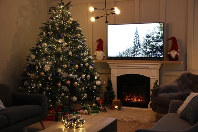 Photo of Cozy living room interior with beautiful Christmas tree near fireplace