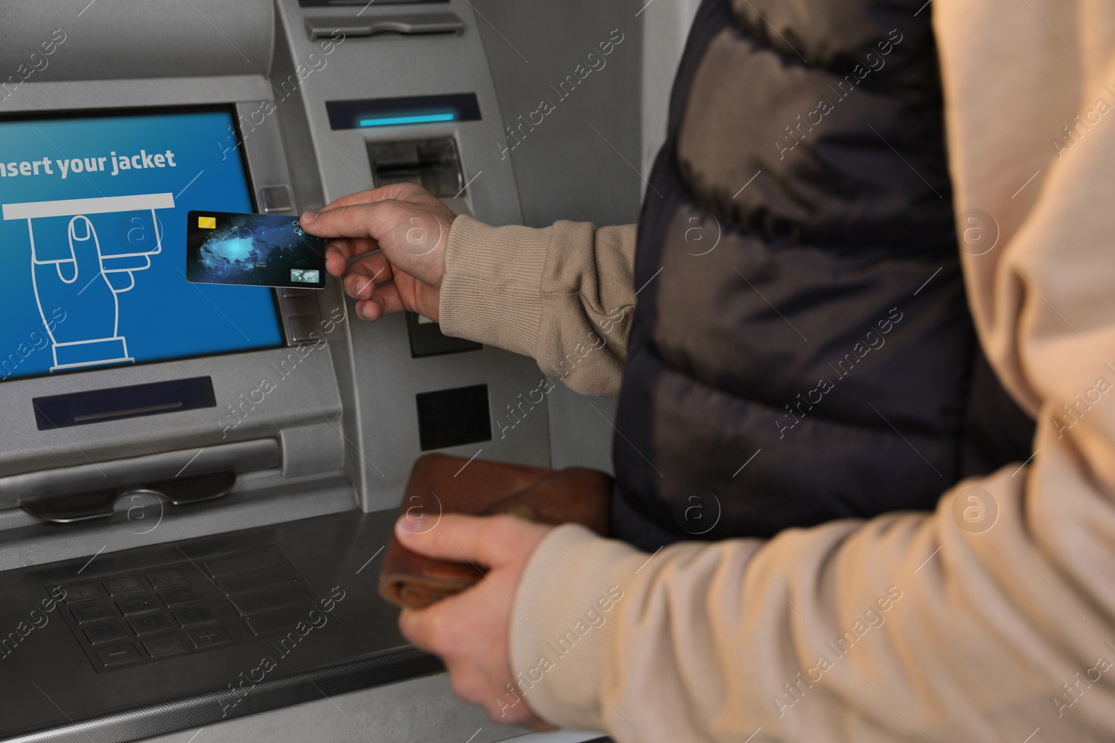 Image of Young man with credit card near cash machine, closeup