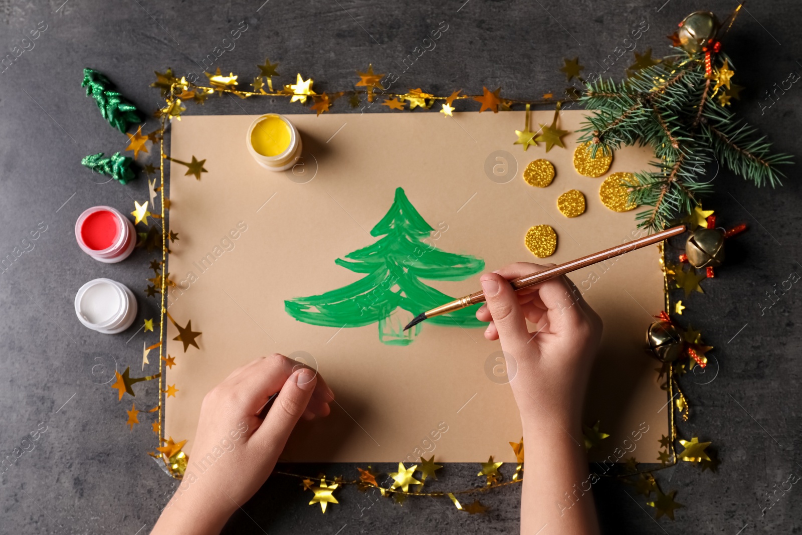 Photo of Little child making Christmas card at black table, top view