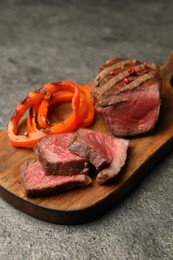 Photo of Delicious grilled beef steak with spices on gray table