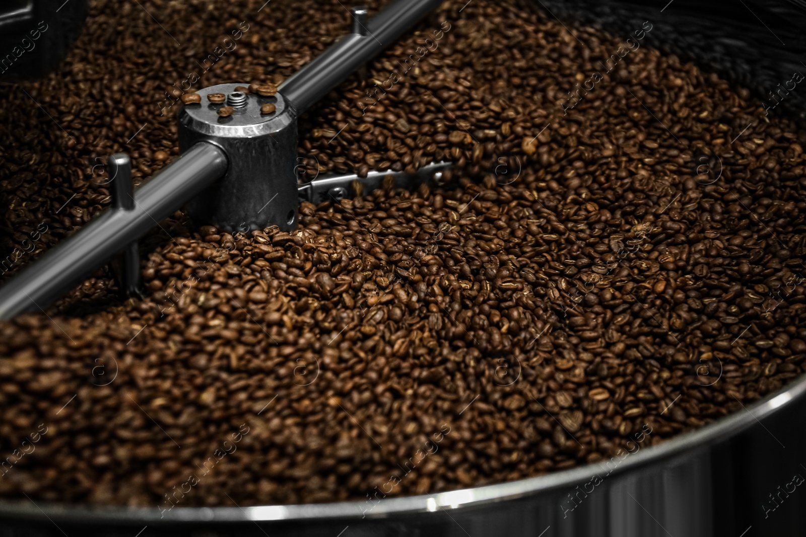 Photo of Modern coffee roaster machine with beans, closeup