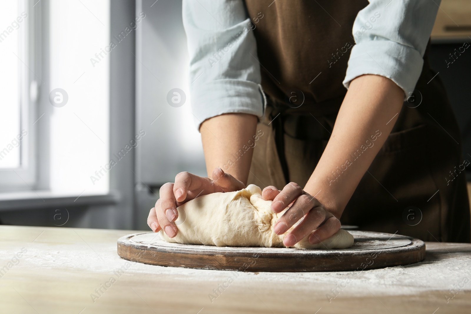 Photo of Female baker preparing bread dough at table, closeup