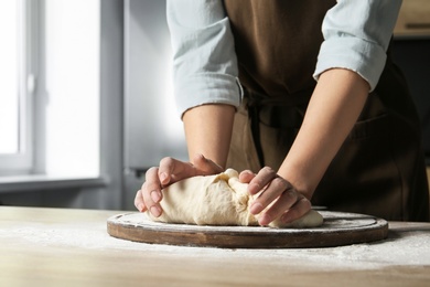 Photo of Female baker preparing bread dough at table, closeup