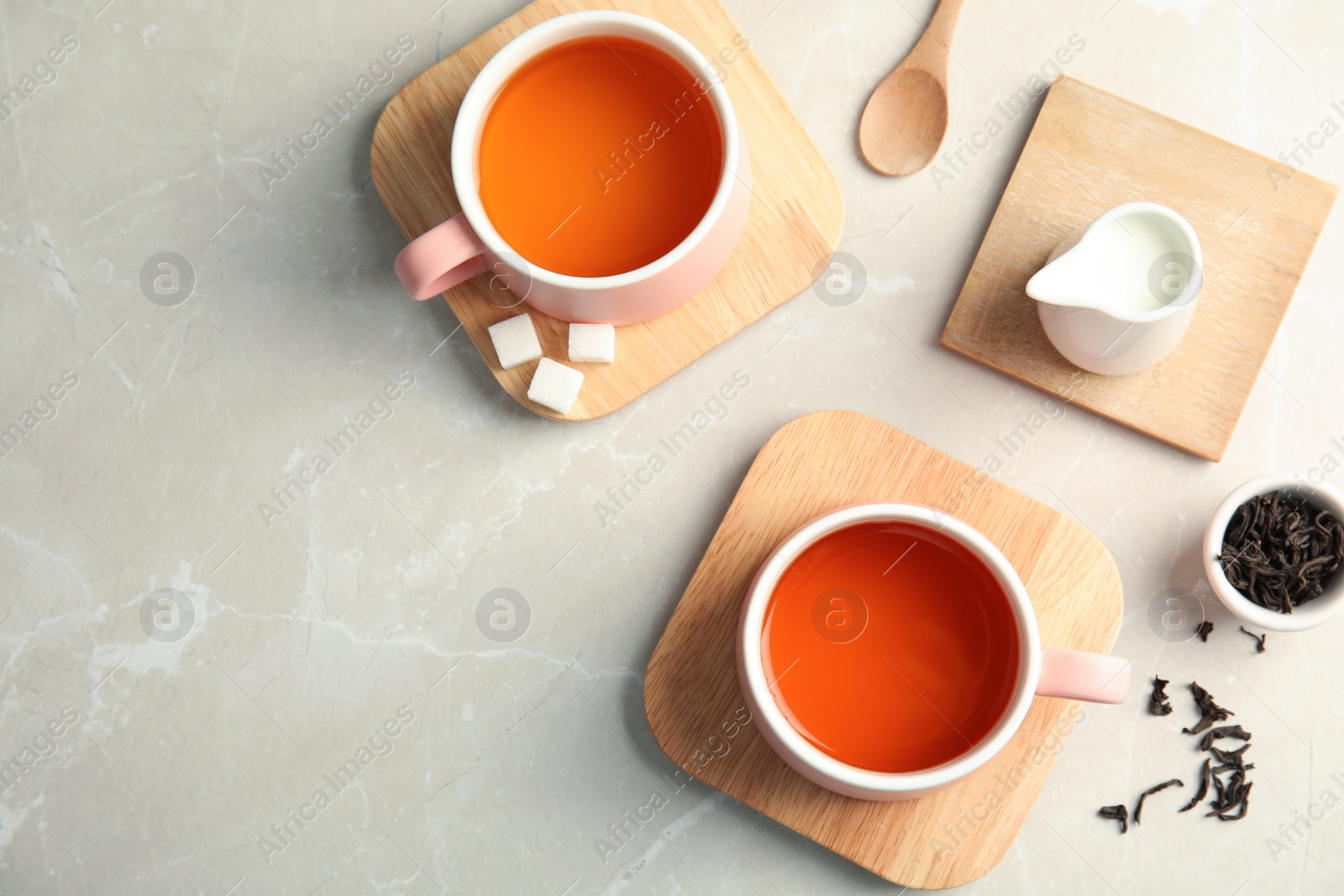 Photo of Flat lay composition with cups of black tea on table, top view