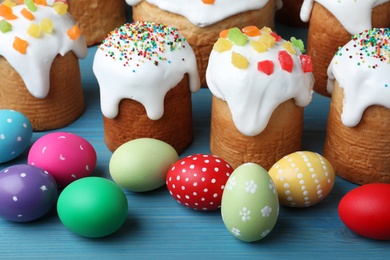 Photo of Traditional Easter cakes and dyed eggs on wooden table