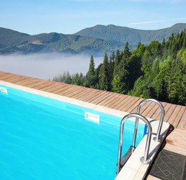 Image of Outdoor swimming pool at luxury resort and beautiful view of mountains on sunny day