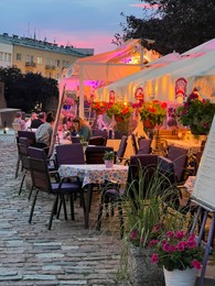 WARSAW, POLAND - JULY 15, 2022: Outdoor cafe terrace on city street in evening