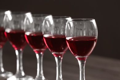 Photo of Glasses with delicious red wine, closeup