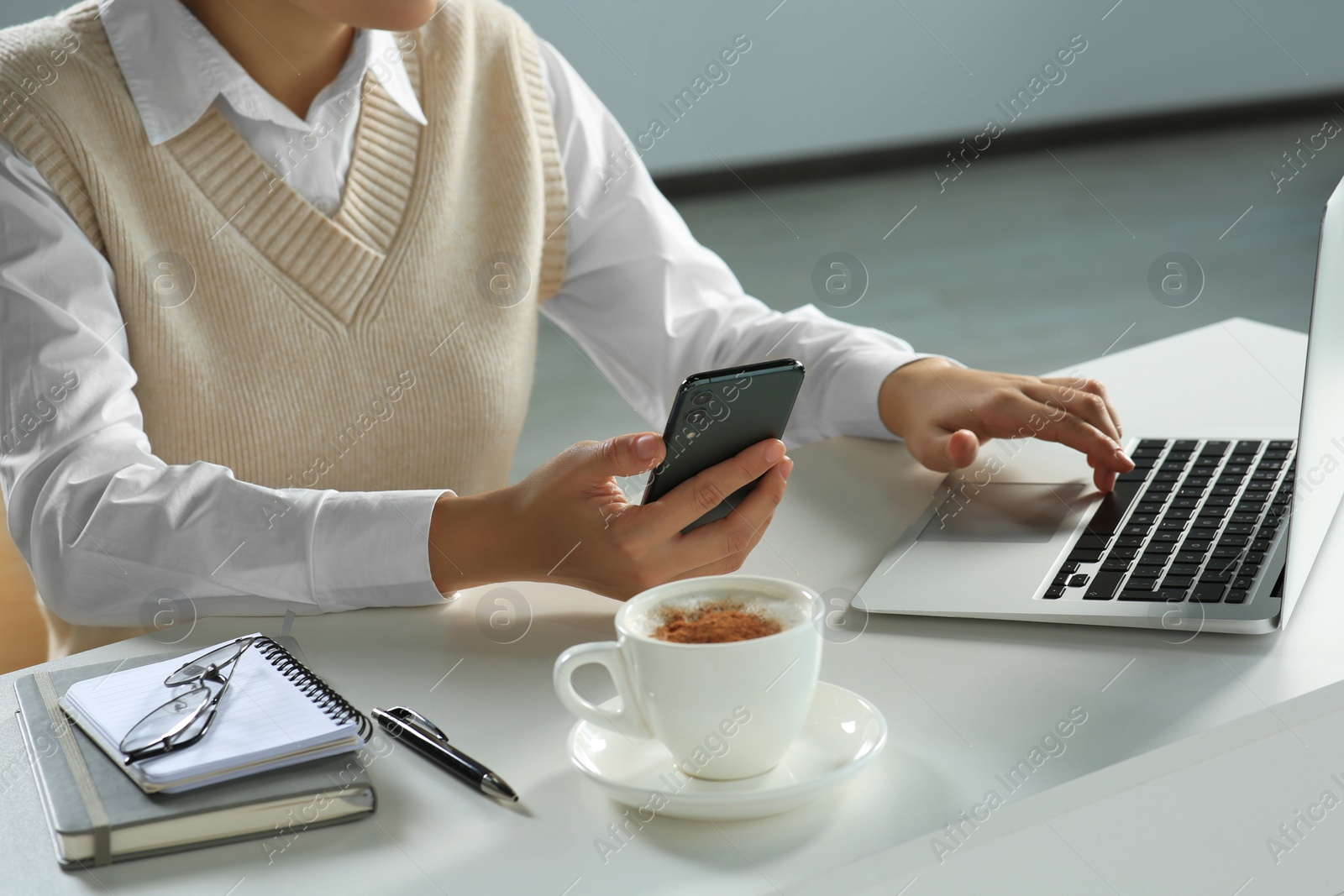 Photo of Woman using smartphone at table indoors, closeup