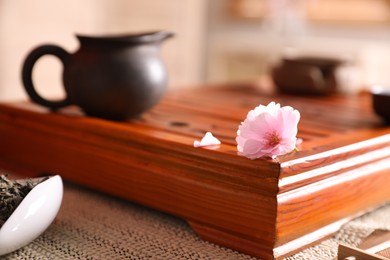 Photo of Tray for traditional tea ceremony with sakura flower on table, closeup